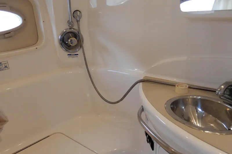 Slide: The Image of 2002 Chaparral Signature 320 boat bathroom with sink and showerhead. - 32