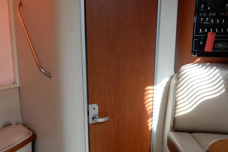 Slide: The Image of Interior of 2002 Chaparral Signature 320 boat, featuring a wooden door and control panel. - 35