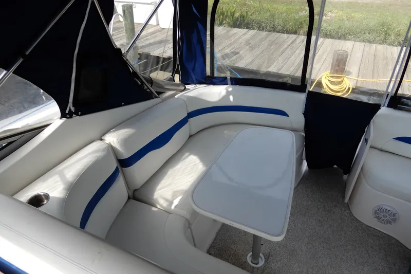 Slide: The Image of 2002 Chaparral Signature 320 boat interior with white and blue seating, table, and canopy. - 7