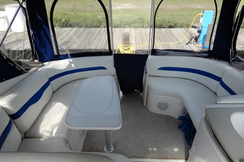 Slide: The Image of 2002 Chaparral Signature 320 boat interior with white and blue seating and table. - 8