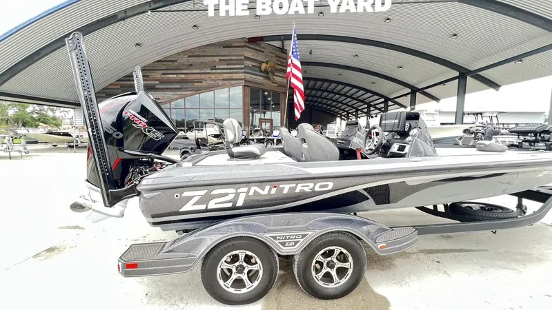 Slide: The Image of 2021 Nitro Z21 boat on trailer at dealership, featuring sleek design and powerful engine. - 7