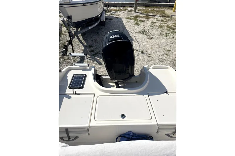 Slide: The Image of 2020 Bayliner Element F18 boat with outboard motor, parked on gravel. - 6