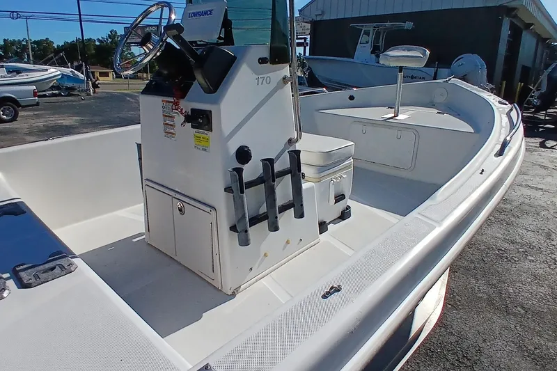 Slide: The Image of 2015 Starcraft 170 boat interior with steering console and seating, parked outdoors. - 6