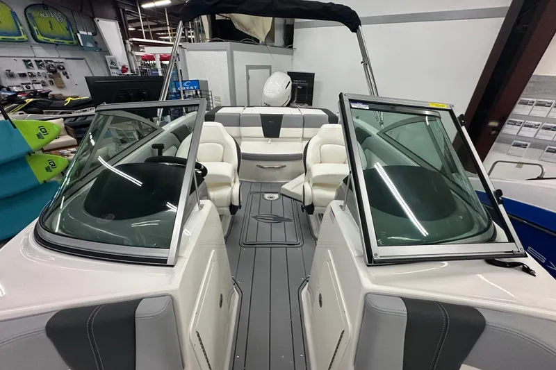 Slide: The Image of 2026 Chaparral 21 SSi boat interior with seating and windshield in showroom. - 15