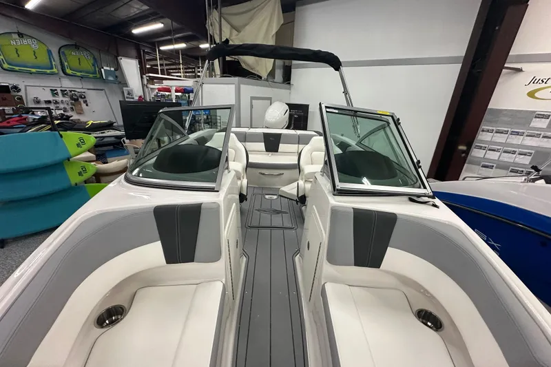 Slide: The Image of 2026 Chaparral 21 SSi boat interior with seating, displayed in showroom. - 16