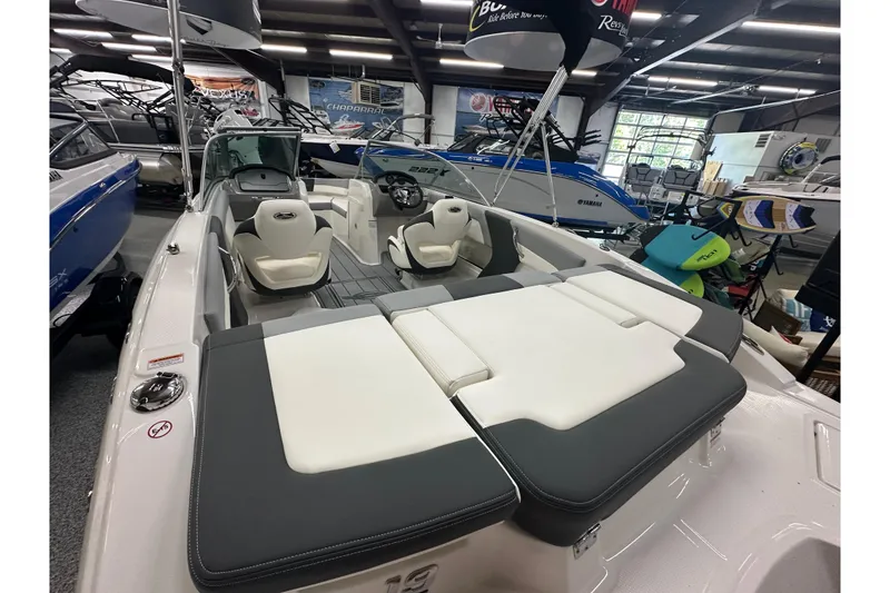 Slide: The Image of 2026 Chaparral 21 SSi boat interior with white and gray seating in showroom. - 5