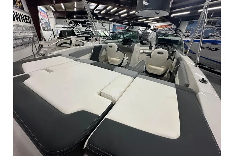 Slide: The Image of 2026 Chaparral 21 SSi boat interior with white and gray seating in showroom. - 6