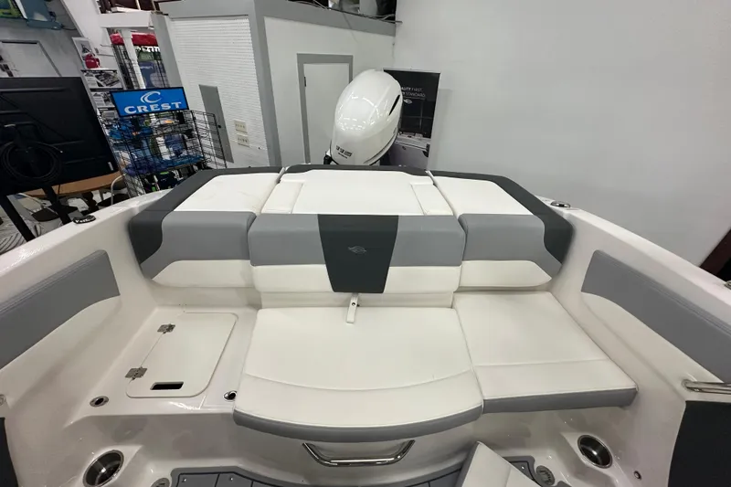 Slide: The Image of 2026 Chaparral 21 SSi boat interior with white and gray seating in showroom. - 8