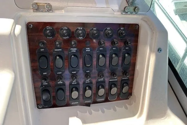 Slide: The Image of Control panel of a 1999 Grady-White Sailfish 272 boat with various switches and dials. - 13