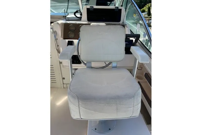 Slide: The Image of Captain's chair on 1999 Grady-White Sailfish 272 boat, featuring white upholstery and armrests. - 17