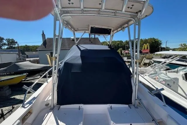 Slide: The Image of 1999 Grady-White Sailfish 272 boat with covered cockpit, docked in a marina. - 23