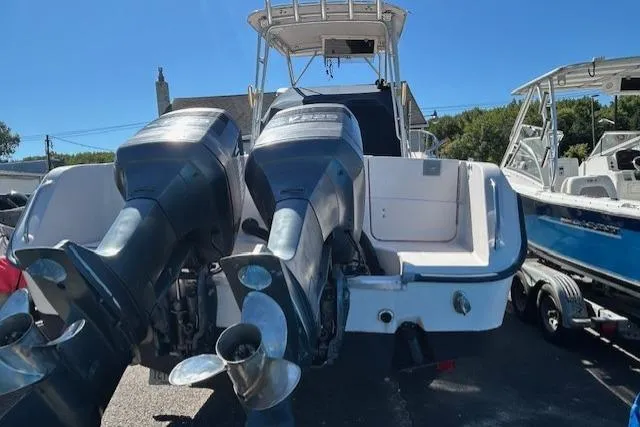 Slide: The Image of 1999 Grady-White Sailfish 272 boat with dual outboard motors, docked outdoors. - 4