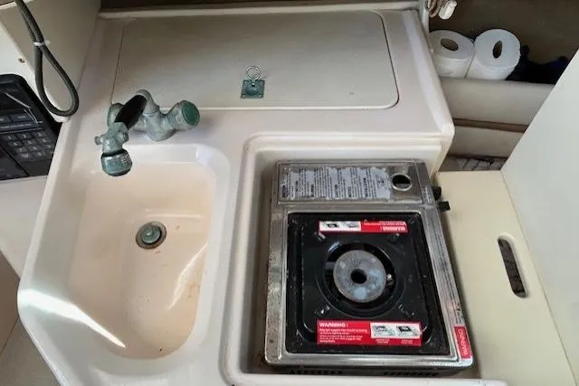 Slide: The Image of 1999 Grady-White Sailfish 272 boat kitchenette with sink and portable stove. - 6