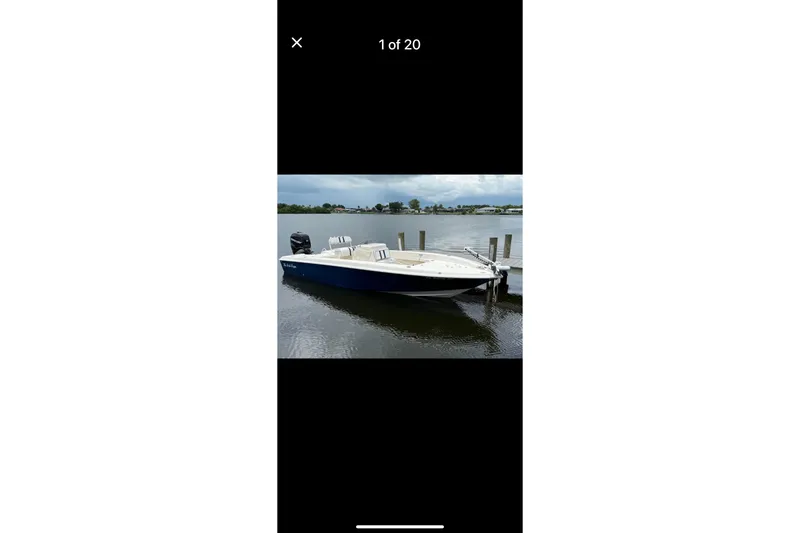 Slide: The Image of 2014 Young Boats 24 Center Console Bay Boat docked on calm water. - 1