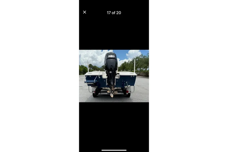 Slide: The Image of 2014 Young Boats 24 Center Console Bay Boat with powerful outboard motor, rear view. - 2