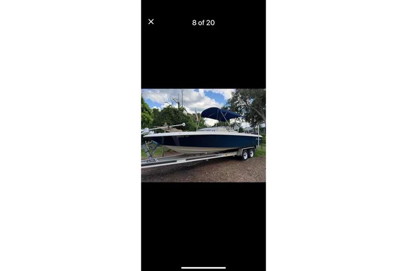 Slide: The Image of 2014 Young Boats 24 Center Console Bay Boat on trailer, blue hull, parked outdoors. - 4
