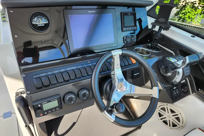 Slide: The Image of 2020 Blackfin 272 DC boat dashboard with steering wheel and navigation controls. - 11