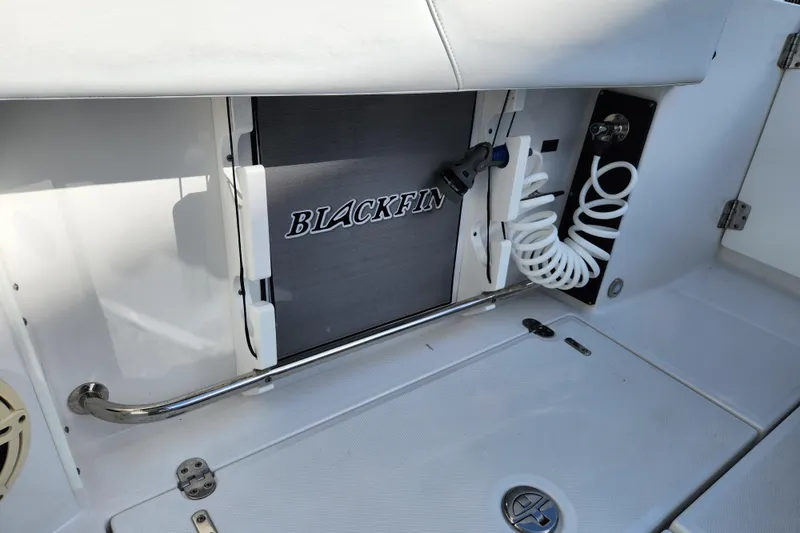 Slide: The Image of 2020 Blackfin 272 DC boat interior with storage compartment and coiled hose. - 20