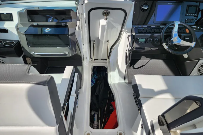 Slide: The Image of 2020 Blackfin 272 DC boat interior with open storage compartment and modern dashboard. - 24