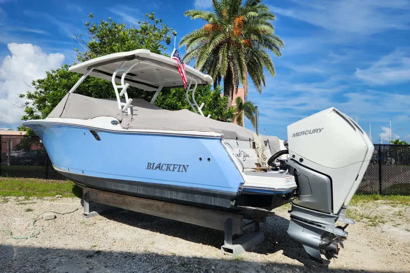 Slide: The Image of 2020 Blackfin 272 DC boat with Mercury engine, parked outdoors under a clear sky. - 30