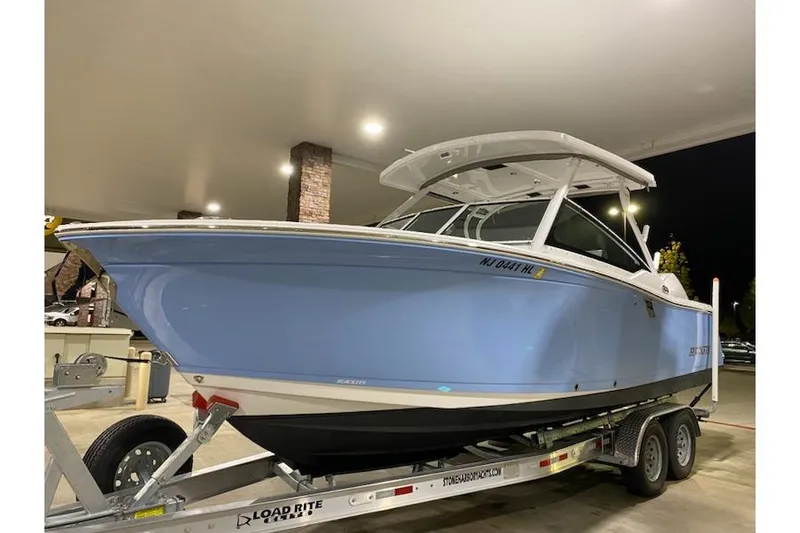 Slide: The Image of 2020 Blackfin 272 DC boat on trailer, displayed indoors under bright lighting. - 33