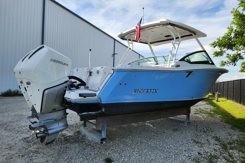 Slide: The Image of 2020 Blackfin 272 DC boat with Mercury engine, displayed outdoors near a building. - 4