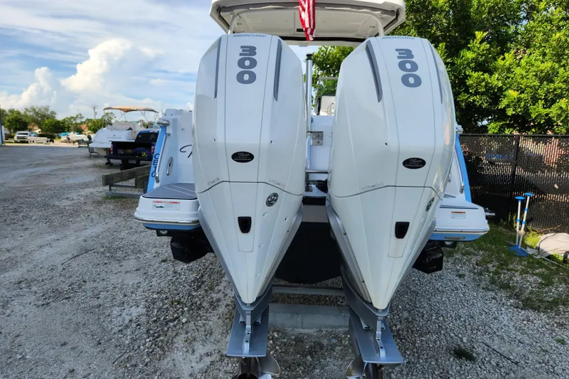 Slide: The Image of 2020 Blackfin 272 DC boat with twin 300 horsepower engines, parked on gravel. - 5
