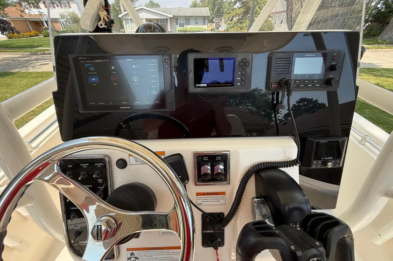 Slide: The Image of 2020 Cobia 220 Center Console boat dashboard with Garmin electronics and steering wheel. - 13