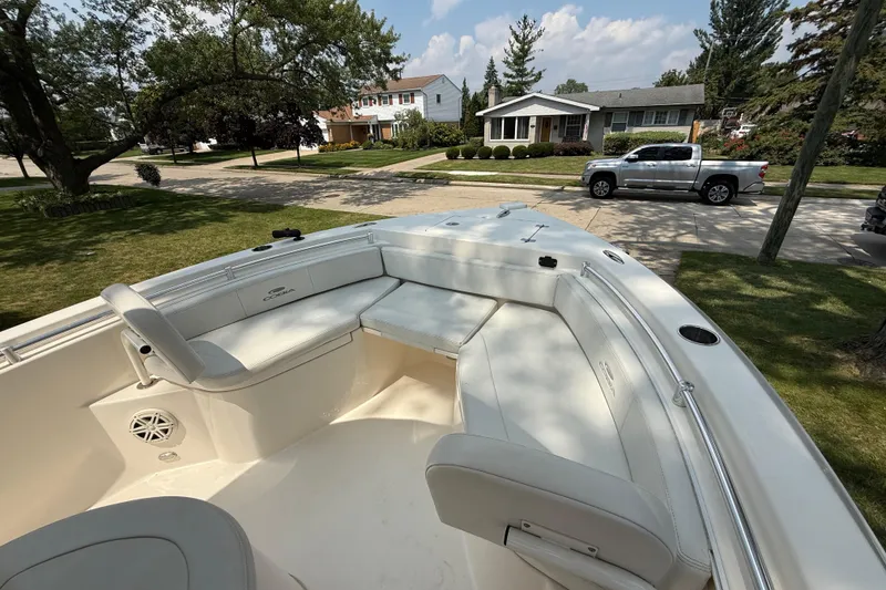 Slide: The Image of 2020 Cobia 220 Center Console boat with seating, parked in a suburban neighborhood. - 22