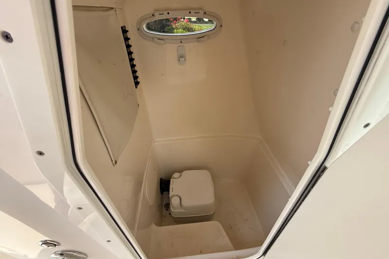 Slide: The Image of 2020 Cobia 220 Center Console boat interior with compact toilet. - 24
