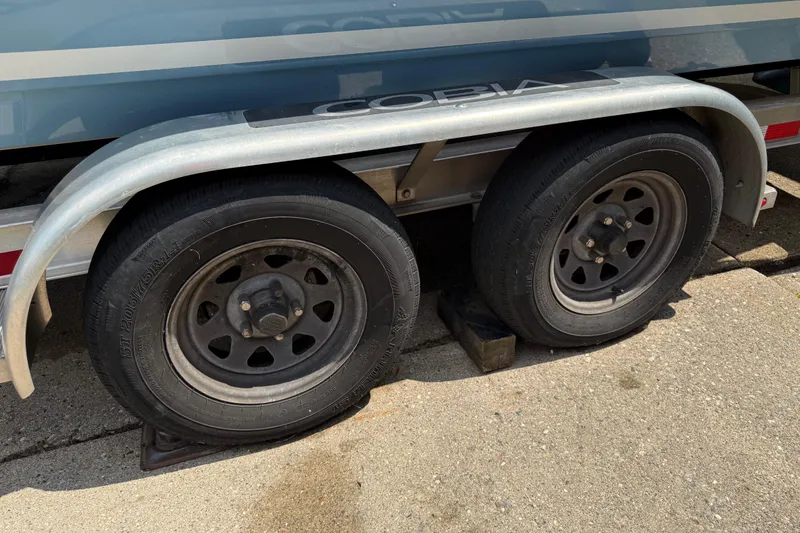 Slide: The Image of Trailer wheels of a 2020 Cobia 220 Center Console boat on pavement. - 25