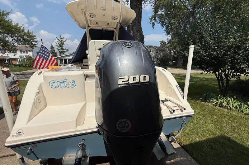 Slide: The Image of 2020 Cobia 220 Center Console boat with 200 horsepower engine, parked in a residential area. - 4