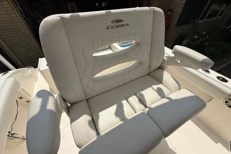 Slide: The Image of 2020 Cobia 220 Center Console boat seat with armrests and logo, in bright sunlight. - 9