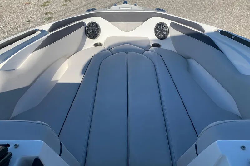 Slide: The Image of 2018 Rinker QX26 BR boat interior with cushioned seating and built-in speakers. - 11