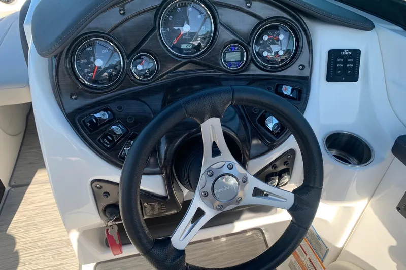 Slide: The Image of 2018 Rinker QX26 BR boat dashboard with steering wheel and gauges. - 13