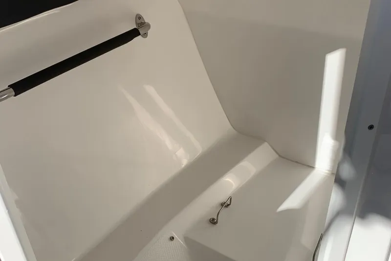 Slide: The Image of Interior of a 2018 Rinker QX26 BR boat, featuring a sleek white design. - 15