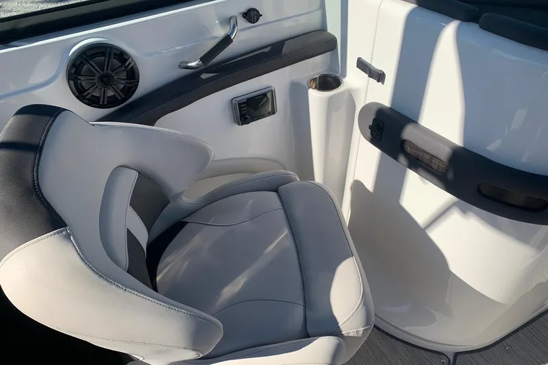 Slide: The Image of 2018 Rinker QX26 BR boat interior with cushioned seat and speaker. - 17