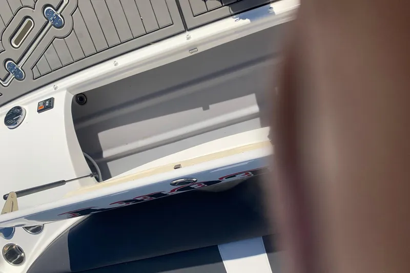 Slide: The Image of 2018 Rinker QX26 BR boat storage compartment with open hatch and sleek design. - 19