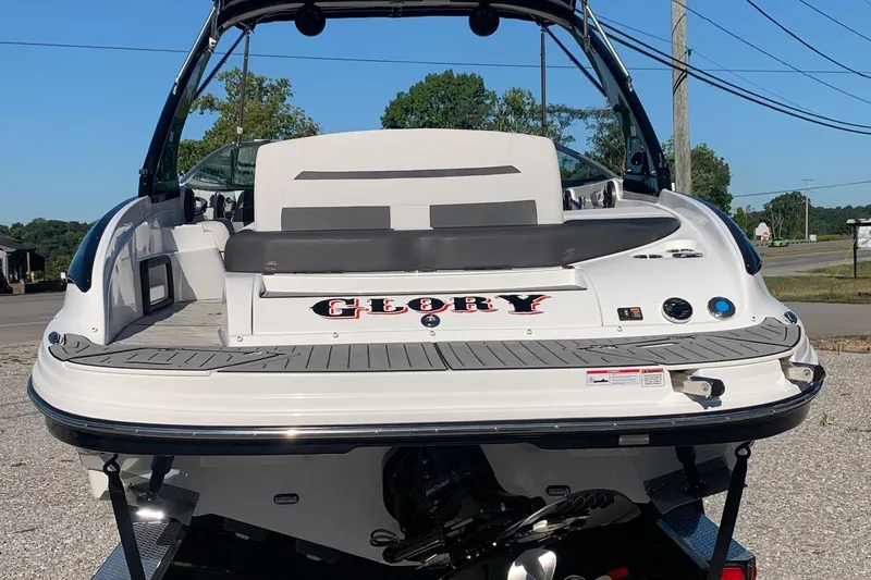 Slide: The Image of 2018 Rinker QX26 BR boat, rear view, parked outdoors on a sunny day. - 3