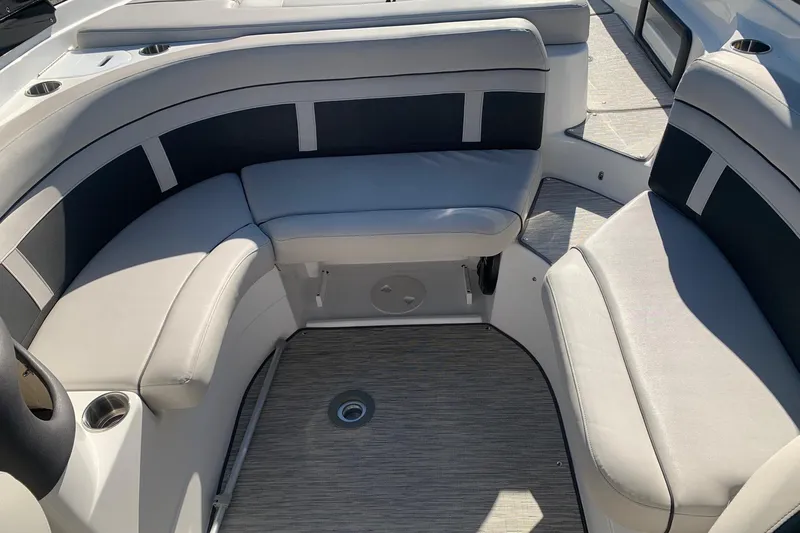 Slide: The Image of 2018 Rinker QX26 BR boat interior with cushioned seating and cup holders. - 6