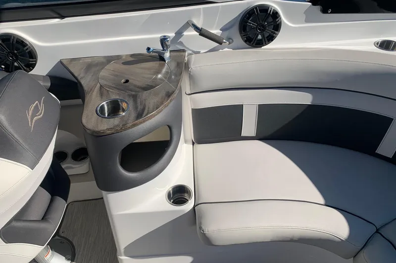 Slide: The Image of 2018 Rinker QX26 BR boat interior with seating, sink, and cup holders. - 9