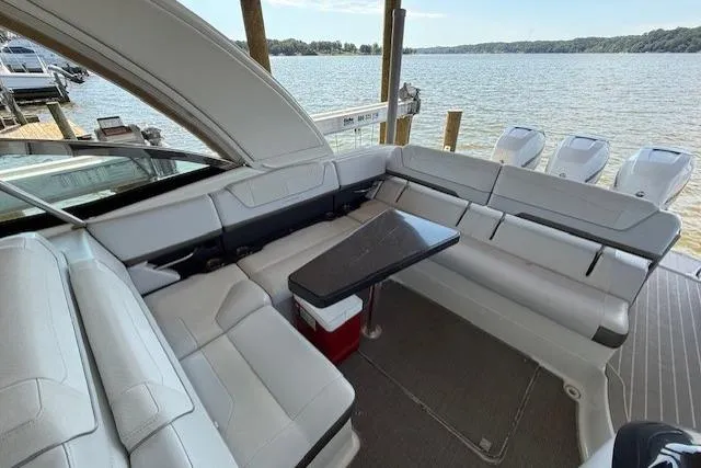 Slide: The Image of 2018 Formula 350 Crossover Bowrider OB interior with seating and table, overlooking a serene lake. - 11