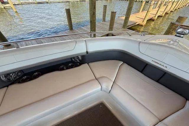 Slide: The Image of 2018 Formula 350 Crossover Bowrider OB interior with plush seating near a dock. - 29