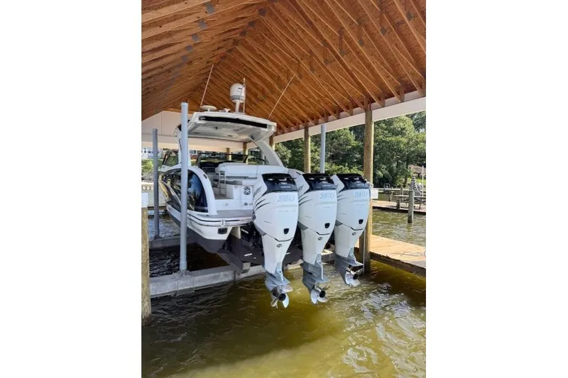 Slide: The Image of 2018 Formula 350 Crossover Bowrider OB with triple outboard engines in a covered dock. - 6