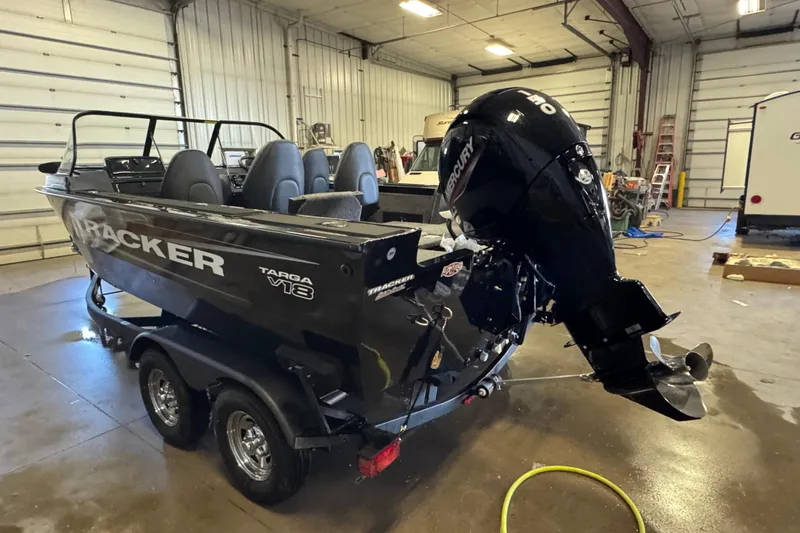 Slide: The Image of 2026 Tracker Targa V-18 Combo boat in a garage with Mercury outboard motor. - 5