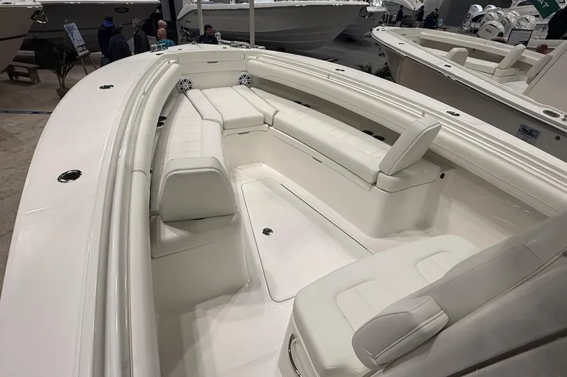 Slide: The Image of 2026 Regulator 25 boat interior with white seating at a boat show. - 2