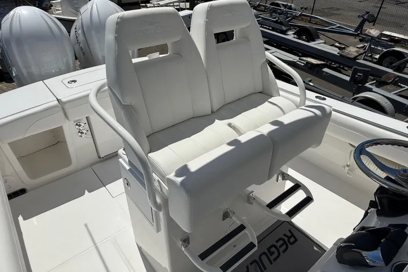 Slide: The Image of 2026 Regulator 25 boat interior with white seating and dual outboard motors. - 21
