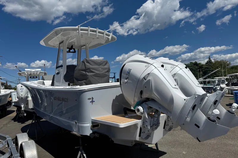 Slide: The Image of 2026 Regulator 25 boat with dual outboard engines, parked under a clear blue sky. - 25
