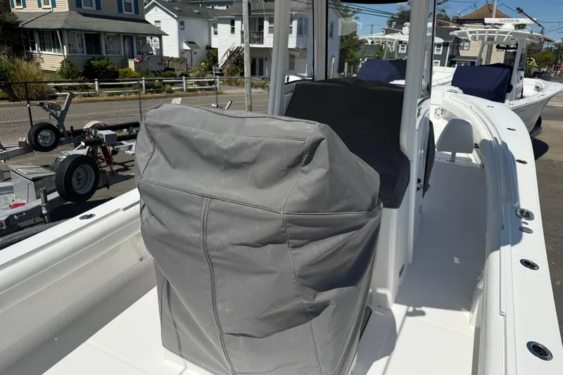 Slide: The Image of 2026 Regulator 25 boat interior with covered console and seating, docked in a residential area. - 28