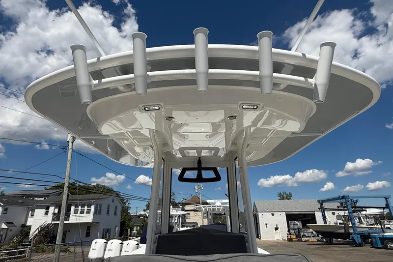 Slide: The Image of 2026 Regulator 25 boat with T-top and rod holders under a clear blue sky. - 29